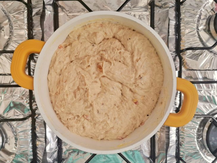 Panela com farinha, manteiga, gemas e o queijo ralado com o creme de frango adicionado.