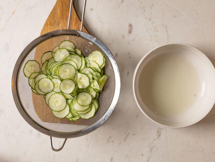 Fatias de pepino para secar em uma peneira.