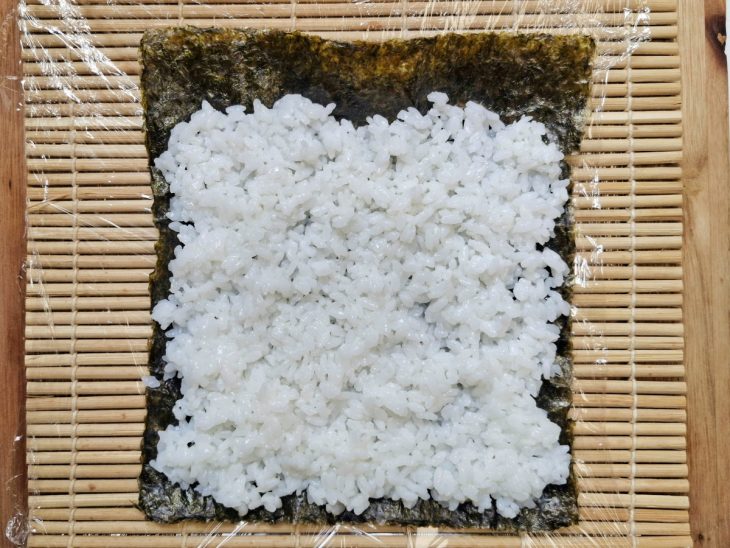 Nori e arroz sobre uma esteira de bambu