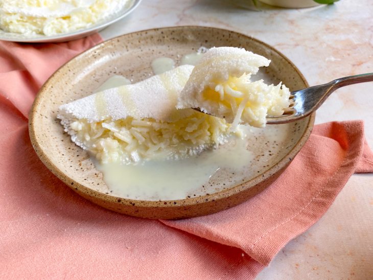 Tapioca recheada em um prato e um pequeno pedaço dela em um garfo.