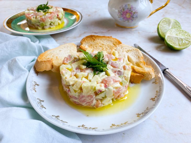 Tartar de salmão pronto para consumo e acompanhado por torradas.