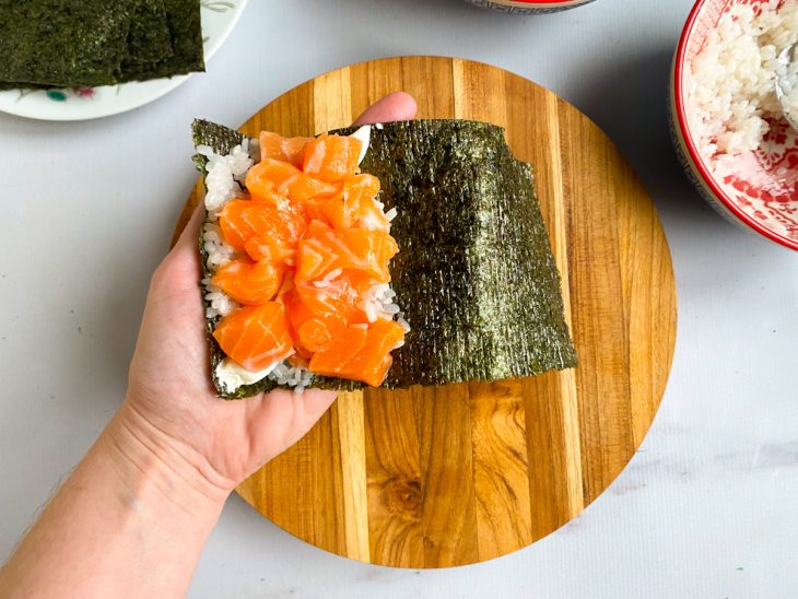 alga nori recheada com arroz, cream cheese e cubos de salmão