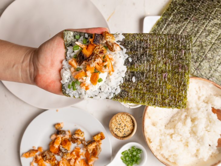 Alga nori recheada com arroz, cream cheese, skin de salmão e cebolinha.