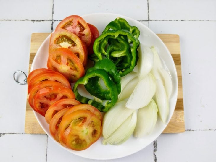 Tomate, pimentão e cebola em cortes.