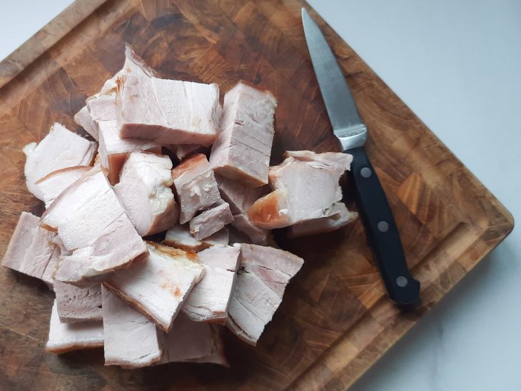 Uma tábua com a carne cortada em pedacinhos.