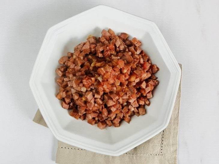 Calabresa refogada com tomate e cebola, acomodada em um prato.