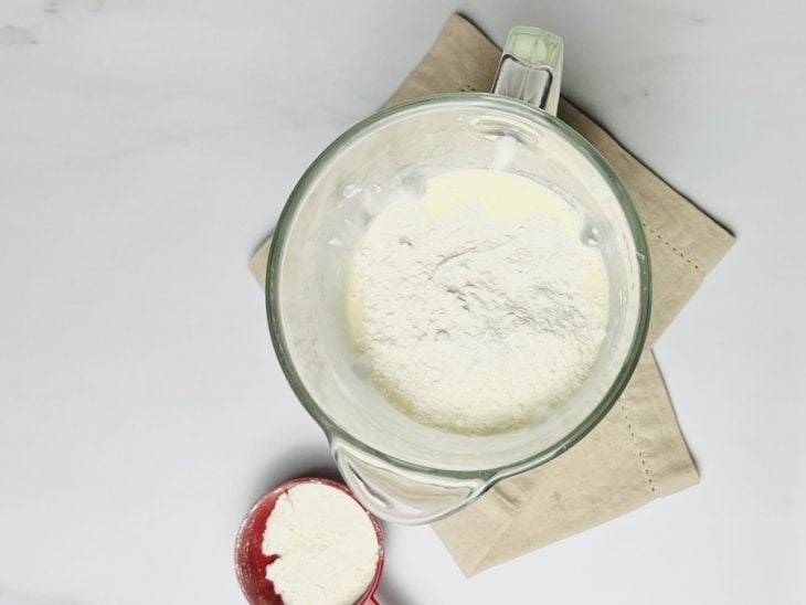 Parmesão e farinha de trigo incorporados na mistura do liquidificador.