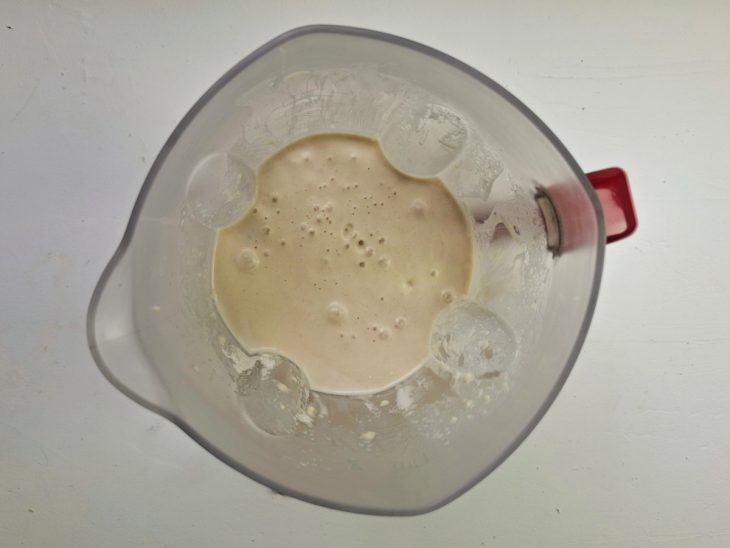 Um liquidificador com ovos, óleo, leite, sal, parmesão e farinha.