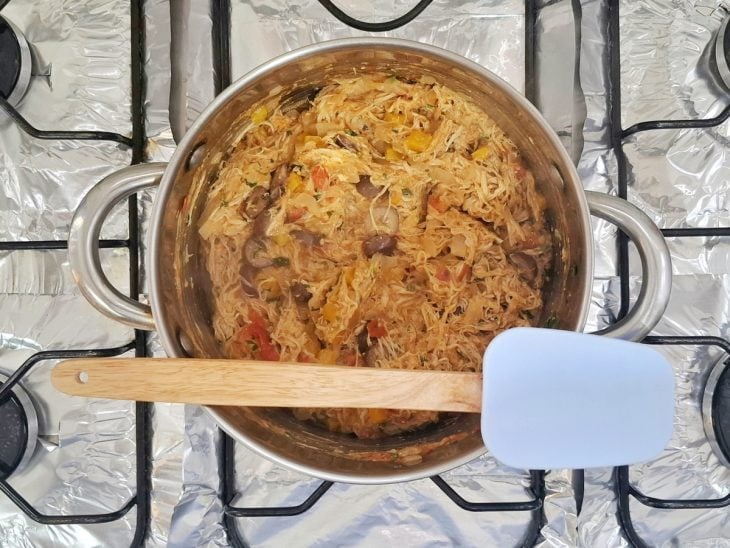 Uma espátula e uma panela ao fogo com o recheio da torta pronto.