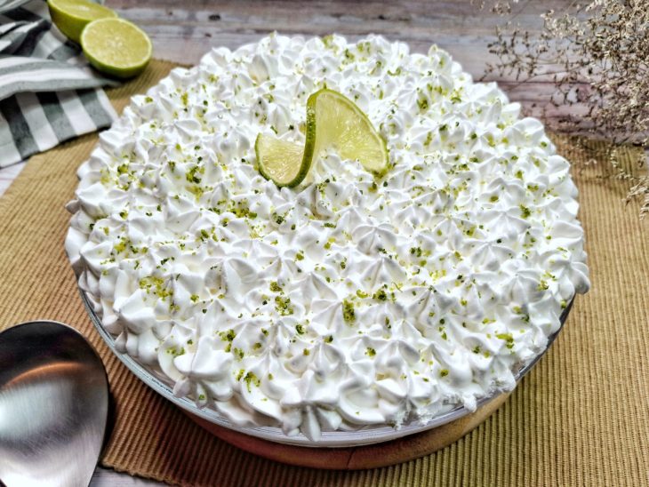 Torta de limão na travessa finalizada e decorada, pronta para servir.