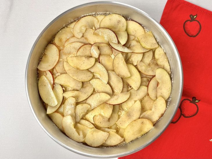 Uma forma forrada com a mistura de farinha coberto com fatias de maçãs.