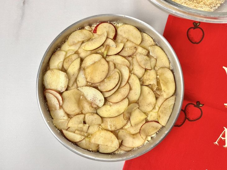 Uma forma forrada com a mistura de farinha coberto com fatias de maçãs.