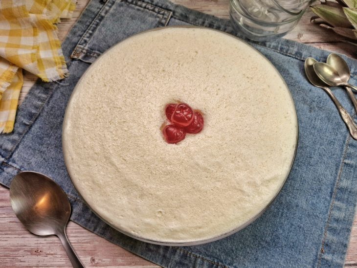 Torta finalizada e decorada com cerejas ao centro sobre um pano