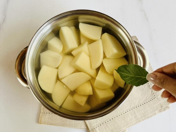 Panela com batatas, sal, água e folha de louro.