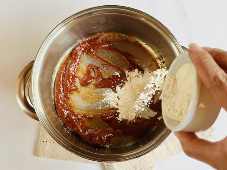 Alho, cebola, extrato de tomate e farinha de trigo na panela.