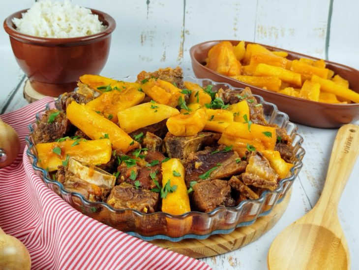 Vaca atolada simples pronta para consumo acompanhada por arroz e mandioca frita.